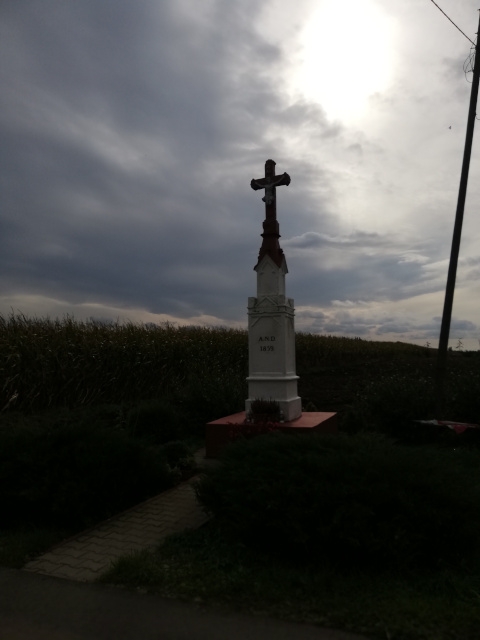 Krzyż na kamiennym postumencie usytuowany przy drodze gminnej Nr 004527T Wlonice - Przybysławice po prawej stronie w stronę Przybysławic z napisem 