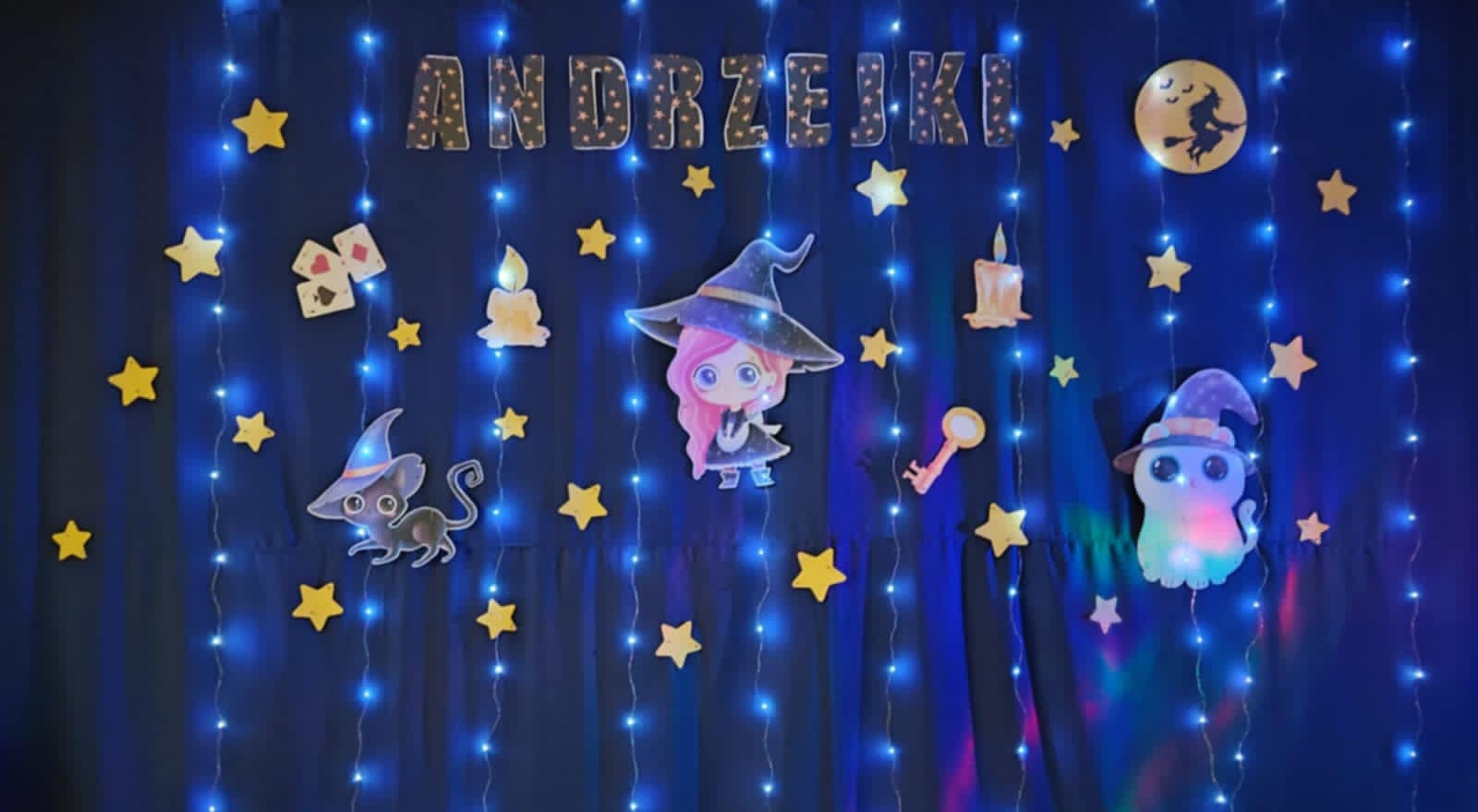 Ozdobna ściana z lampkami i dekoracjami z napisem andrzejki